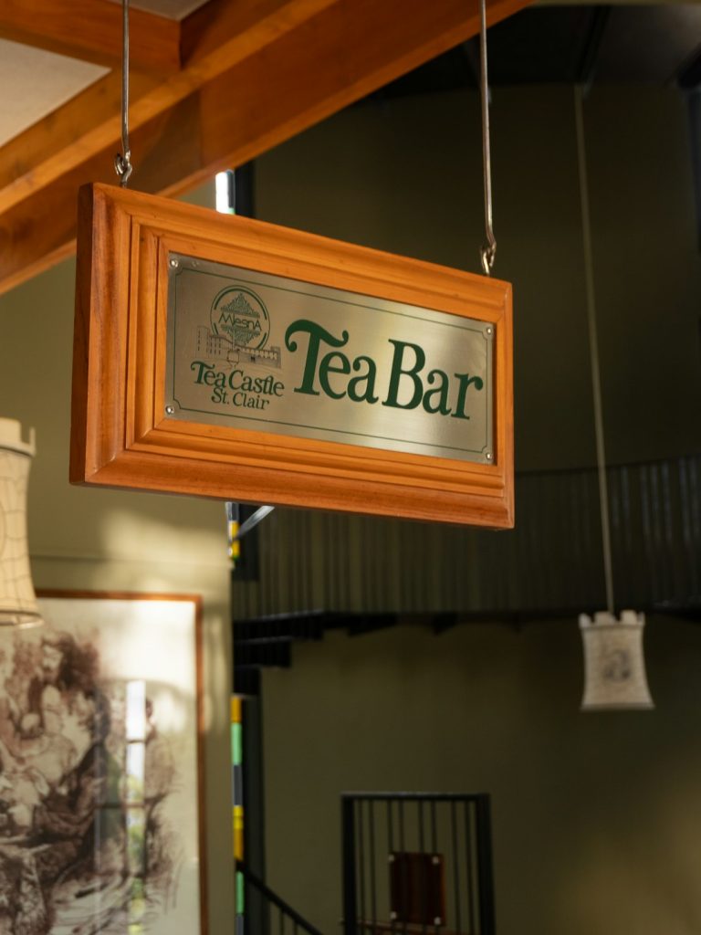 The Art of Drawing Readers In: Your attractive post title goes here A close-up of a quaint tea bar sign hanging outside a cozy tea shop. The warm lighting and rustic wooden sign evoke a charming and inviting atmosphere, ideal for a relaxing tea experience in Sri Lankas renowned tea regions.